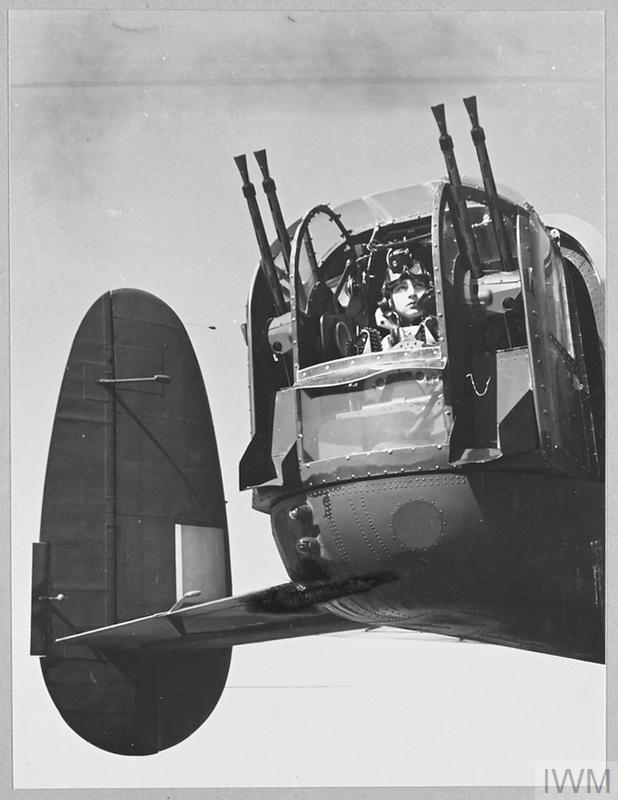 Historic black and white photograph of the rear turret of a Lancaster bomber with the rear gunner in post.