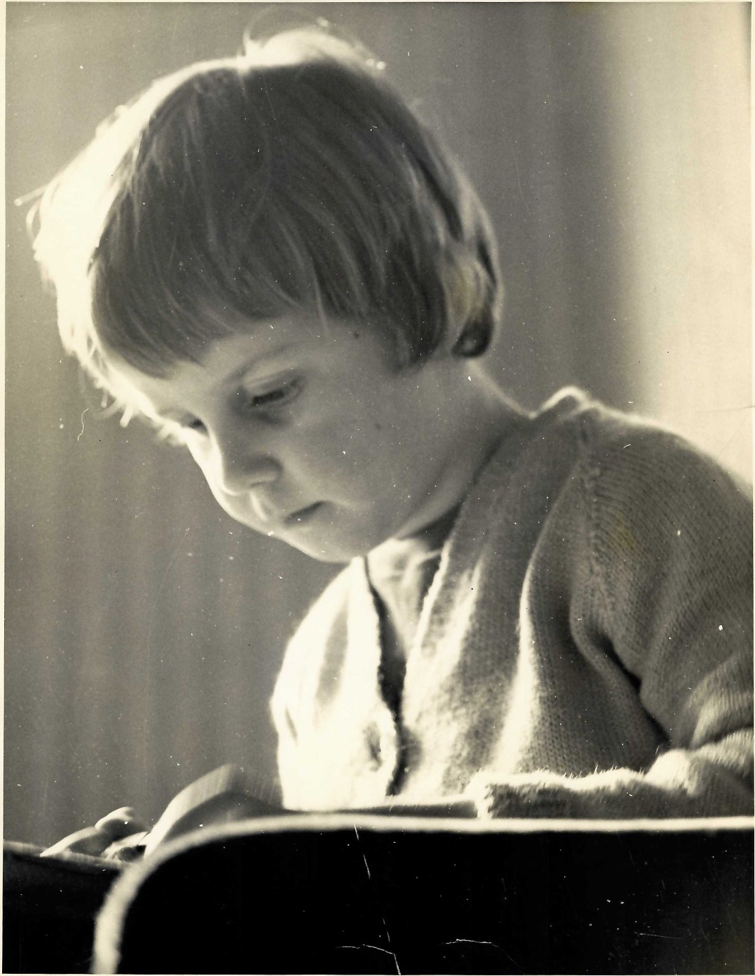 Black and white image of a young girl c1963 concentrating on an unknown task