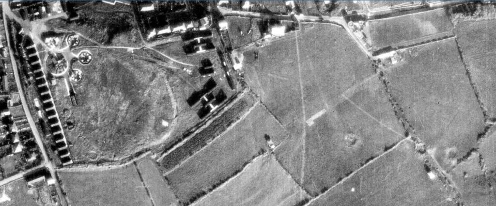 black and white aerial photograph of Barrow Camp in Wyke Regis, Dorset, showing the Heavy Artillery Anti-Aircraft Battery on the left and bomb craters in the fields on the lower right
