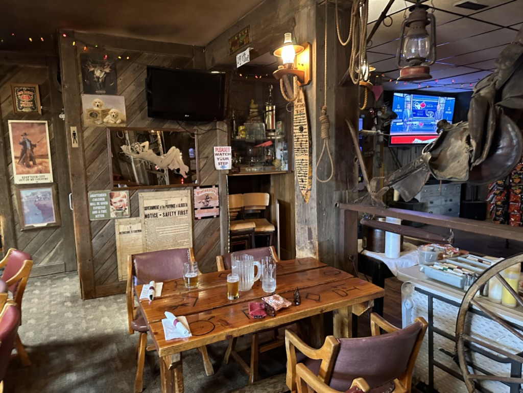 Interior of the Patricia Hotel, Patricia, Alberta, Canada, with walls and tables made from recycled wood and various prairie memorabilia and pctures hanging from the walls