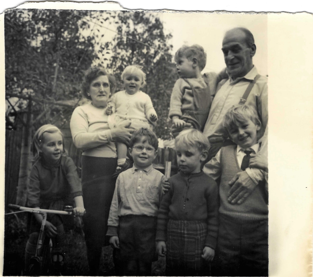 Black and white photo from the early 1960s with six children aged about 7 to 1 with their grandparents.
