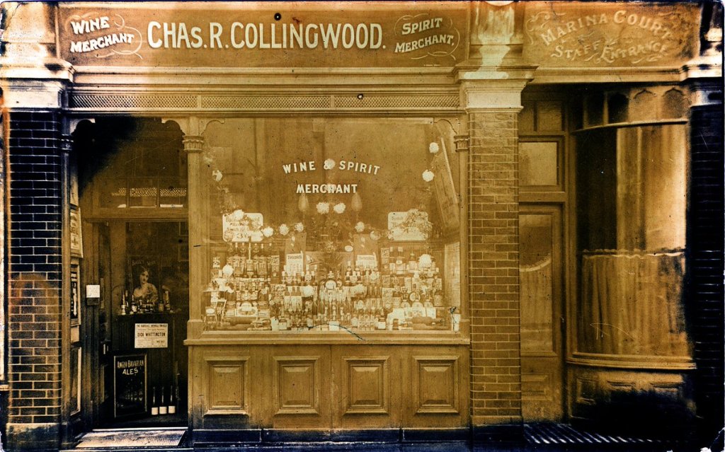 sepia photograph of a shop front in Bexhill c. 1905 with the sign above showing Wine Merchant / Chas R Collingwood / Spirit Merchant