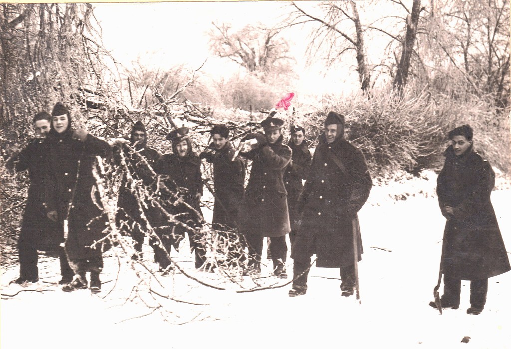 Black and white image of nine prisoners of war in the snow