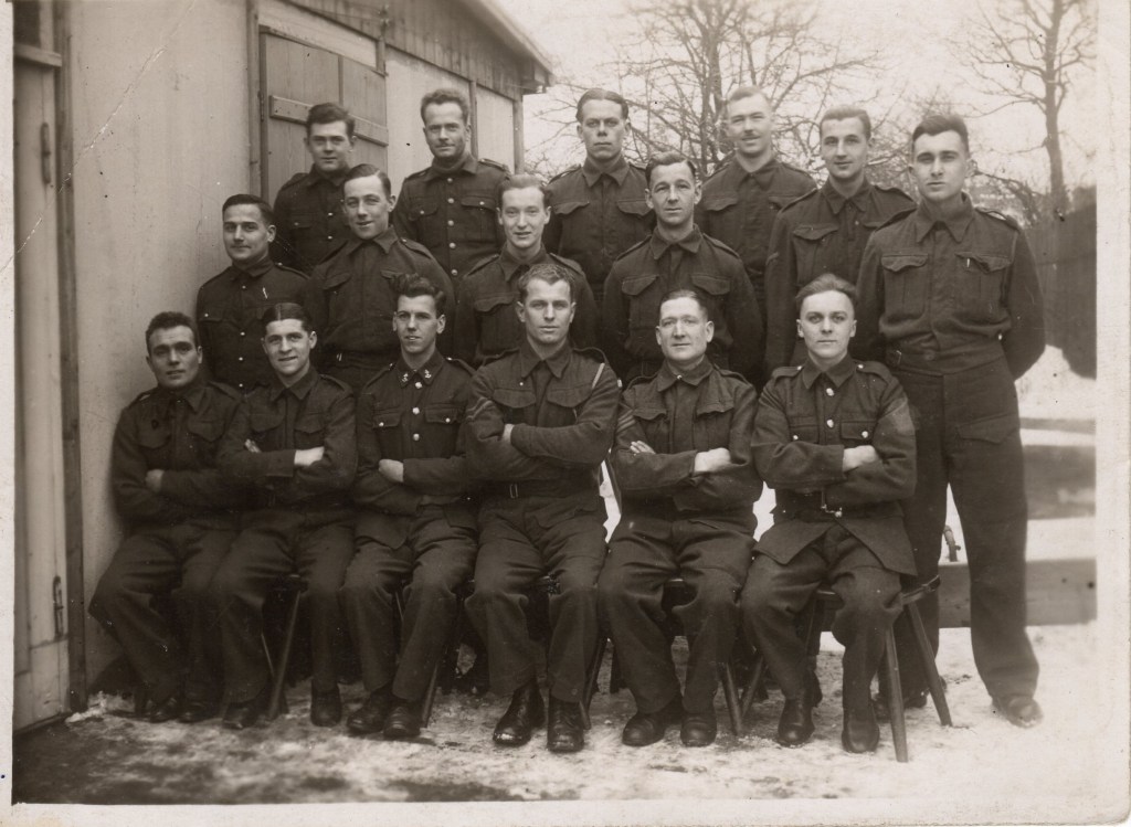 Formal group photograph by the International Red Cross showing a group of British POW in winter with snow on the ground 