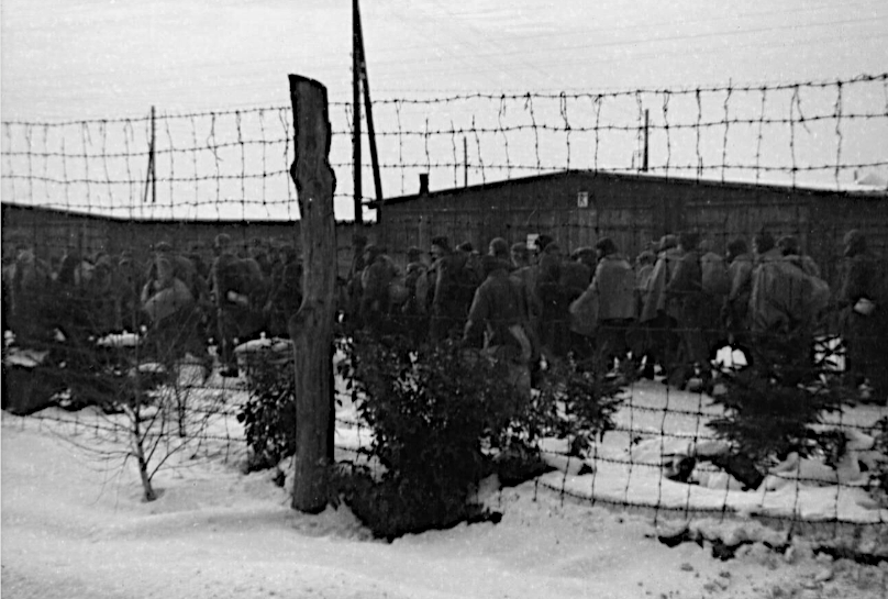 Group of POWs behind a barbed wire fence setting of on the Long March