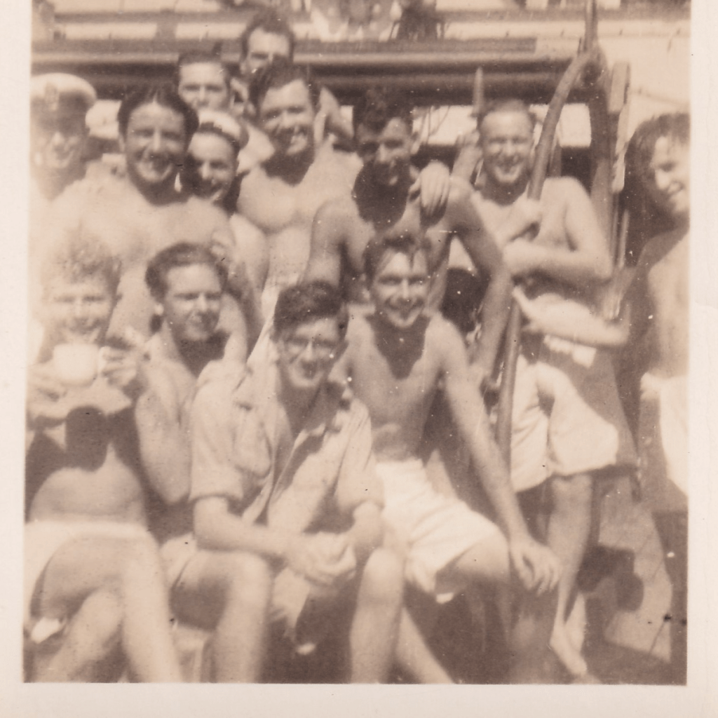 Black and white photograph of a group of smiling young men wearing white shorts aboard HMS Pickle c.1945