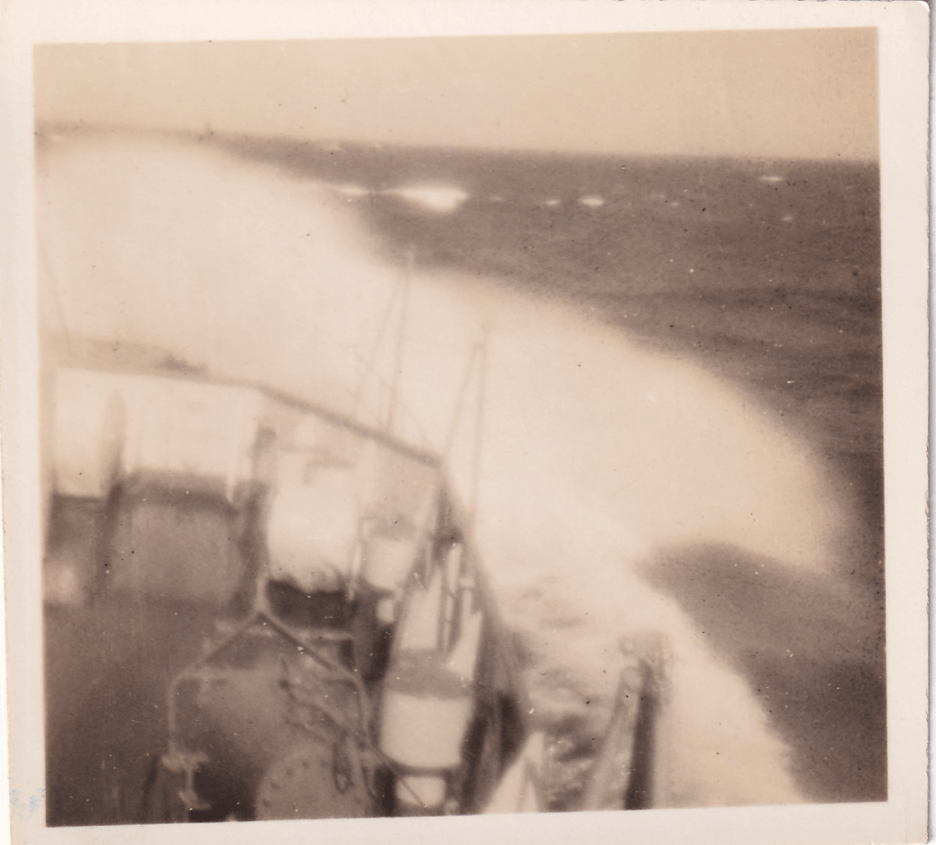 Black and white photograph of the bow of a ship in high seas