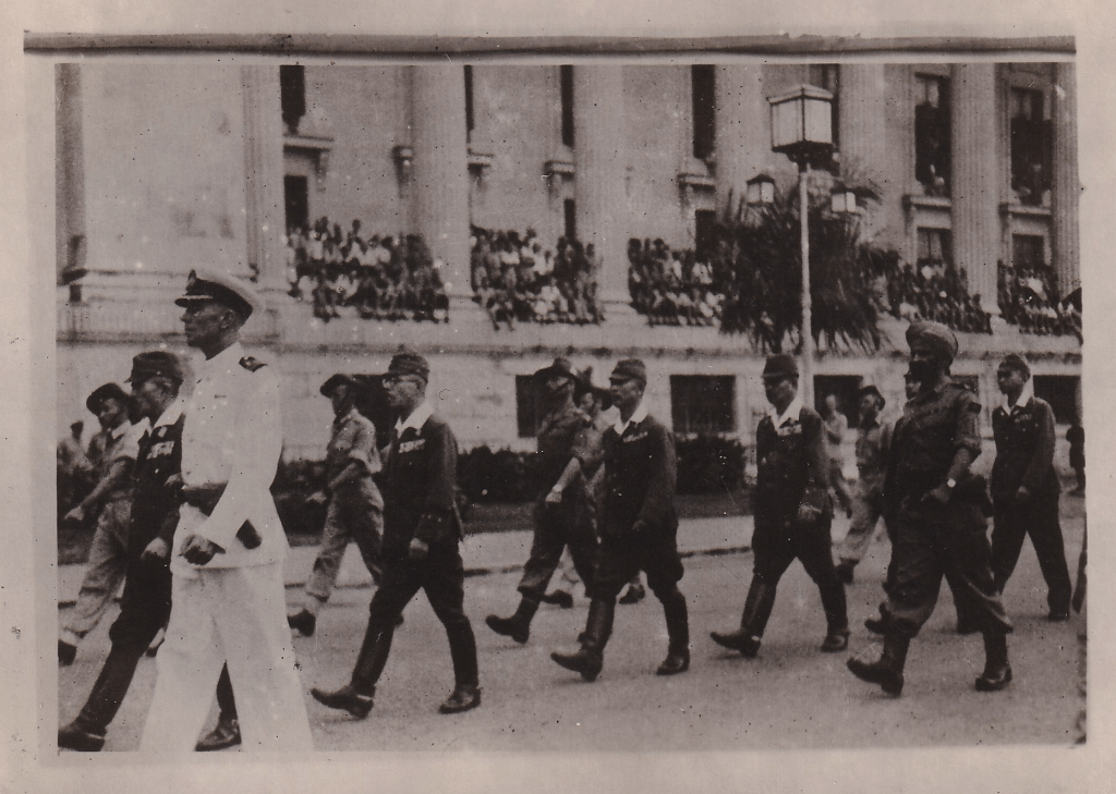 Black and white photograph showing Japanese General Itagaki and other senior Japanese officers being escorted to the Singapore Municipal Buildings for the signing of the surrender terms at the Municipal Building Singapore on 12 Sep 1945