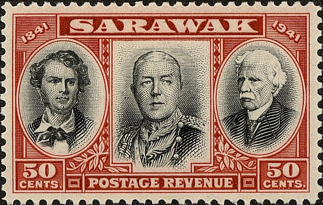 Dark red and black 50 Cents postage stamp from Sarawak marking the 1841-1942 centenary of the Brooke dynasty showing images of the White Rajas