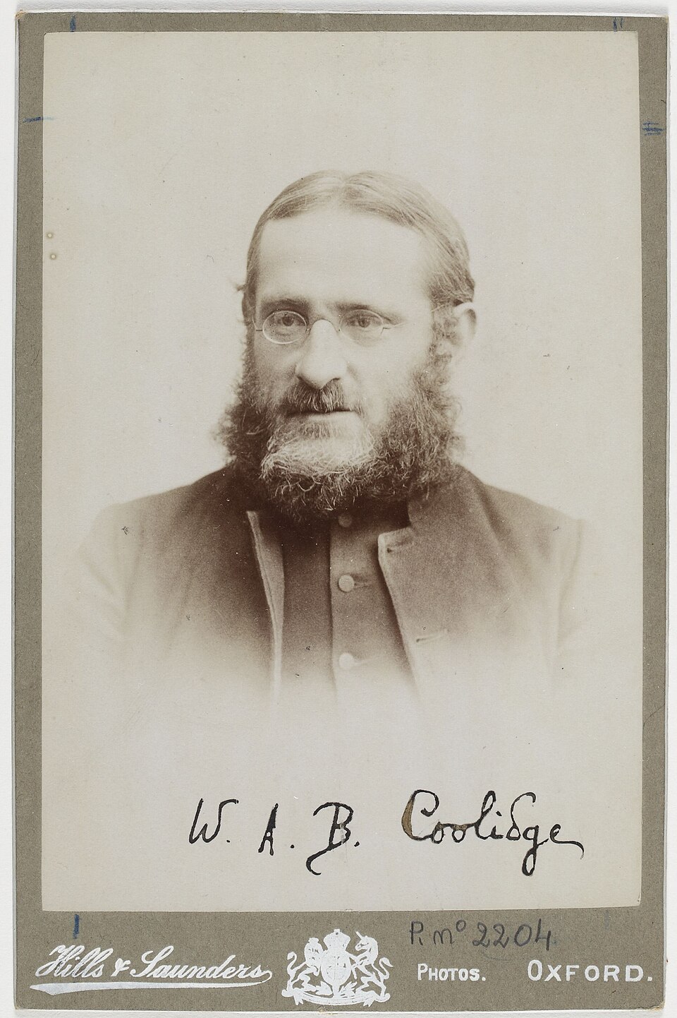 Studio portrait of W. A. B. Coolidge wearing glasses and a full beard